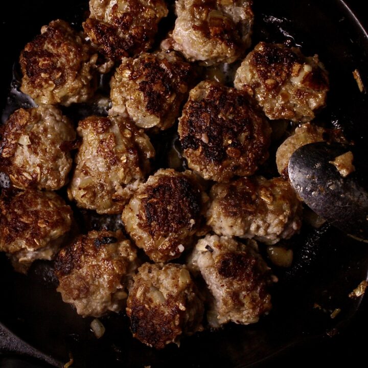 Swedish meatballs cooking in a cast iron skillet