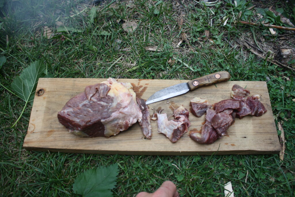 meat on a cutting board with a knife