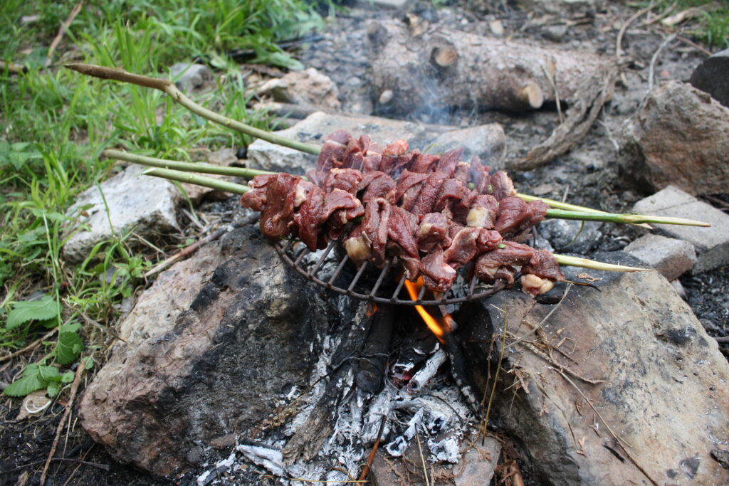 kebab skewers on grilling on a campfire