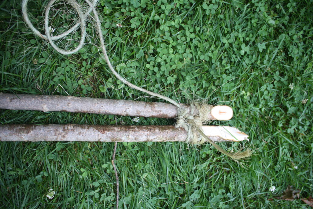 willow poles tied to together with twine to make a garlic drying rack