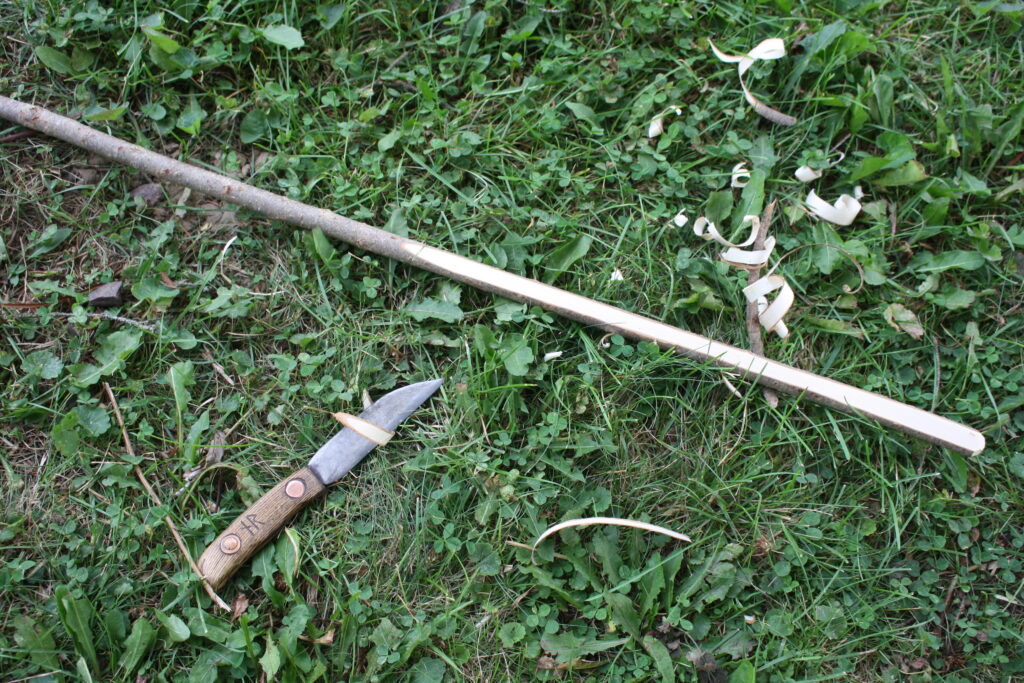 shaving off wood to make a bow