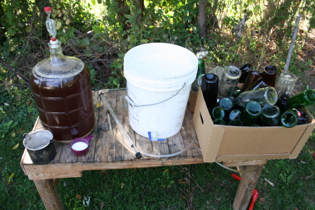 a wooden table with beer bottling equipment displayed on top of it.