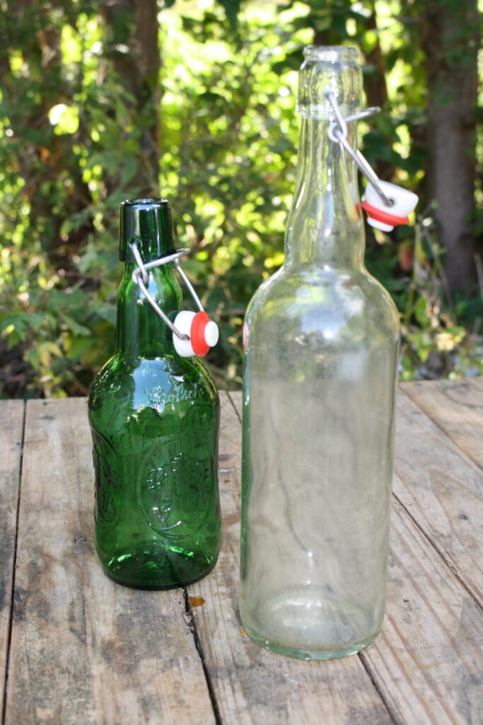 a short green bottle and a tall clear bottle with flip-tops