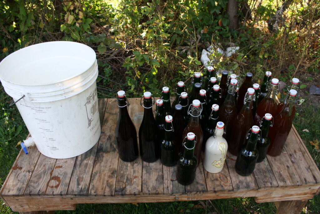 plastic pail and glass bottles of beer on a wooden table