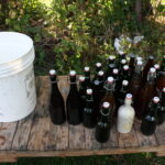 plastic pail and glass bottles of beer on a wooden table