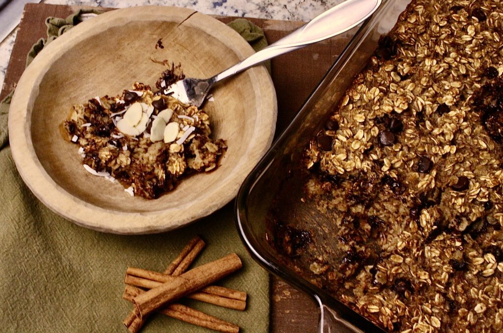 pan of oatmeal bake with spent grains and scoop taken out in a bowl next to it