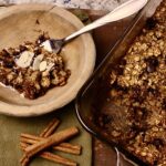 pan of oatmeal bake with spent grains and scoop taken out in a bowl next to it