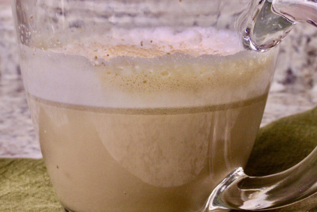 Cup of cinnamon vanilla coffee in a clear mug with foam on top