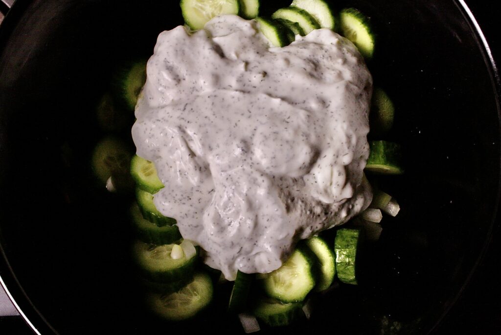 sliced cucumbers with glob of dressing on top