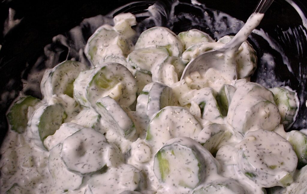 Creamy cucumber salad in a black bowl