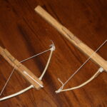 two wooden toy crossbows with a q-tip