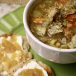 soup in a bowl next to flatbread on a plate