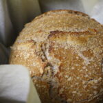 baked sourdough boule on parchment paper