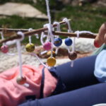 hand holding wooden sicks with wooden beads tied to them