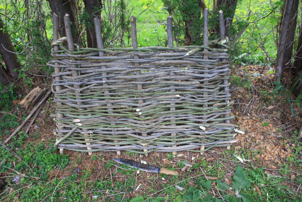 a finished hurdle with a bush-knife sitting on the ground in front of it.