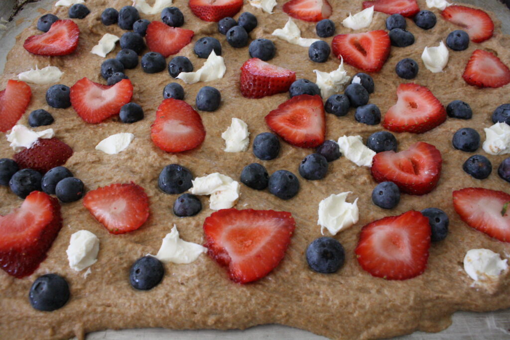 blueberries, strawberries, and cream cheese cubes on focaccia