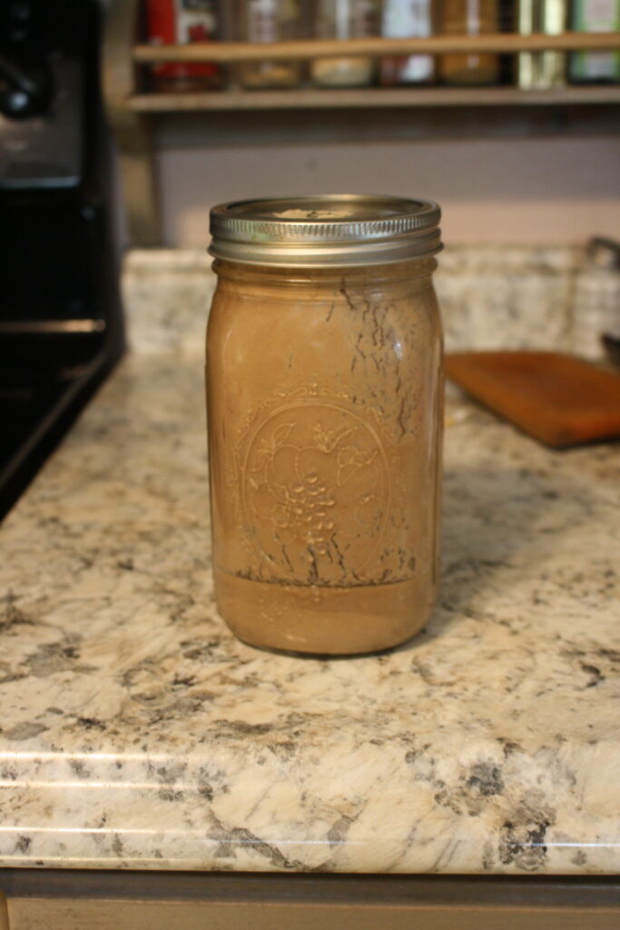 a glass mason jar of Norwegian ale-yeast sitting on a kitchen counter