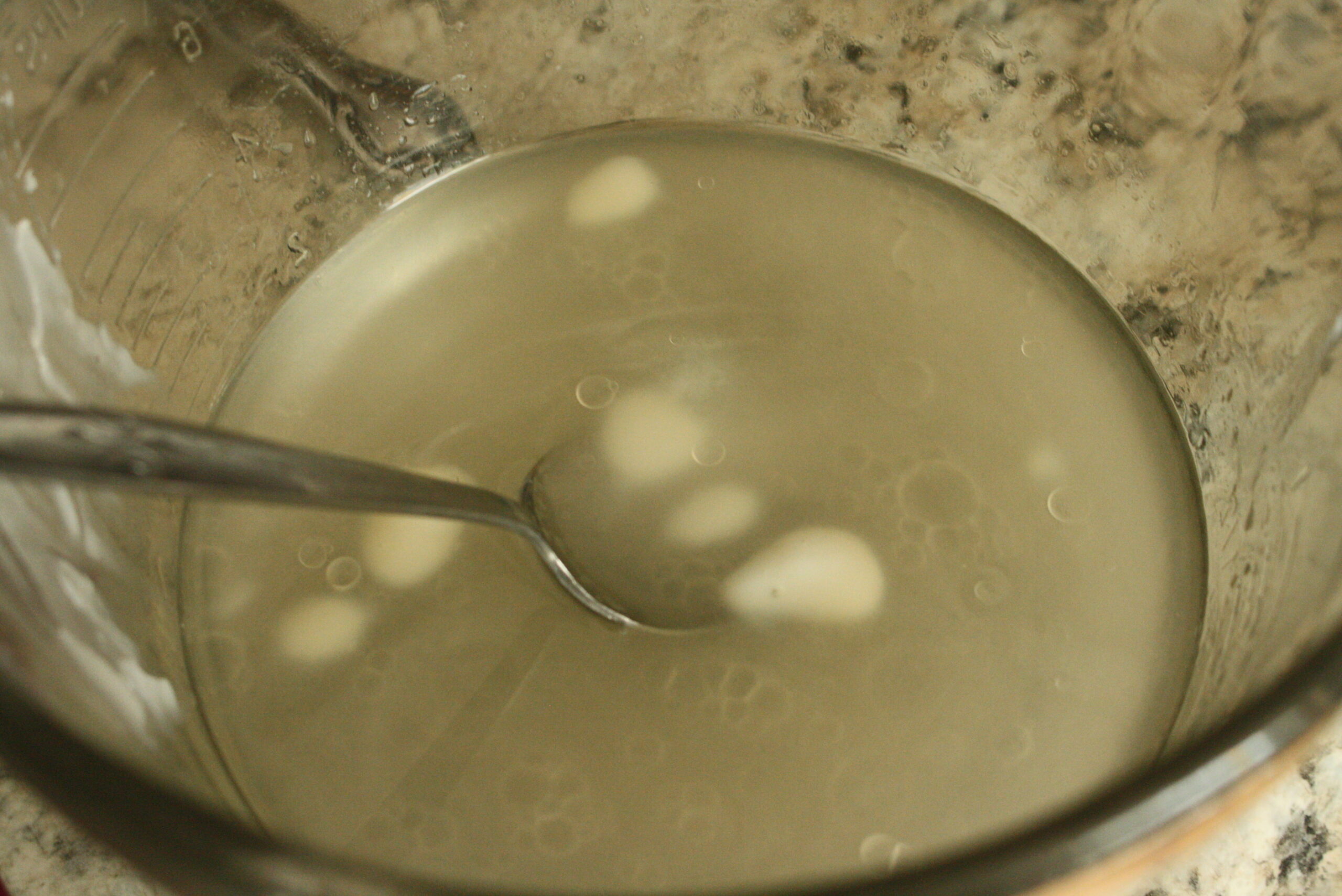 lard clumps melting in a bowl of hot water