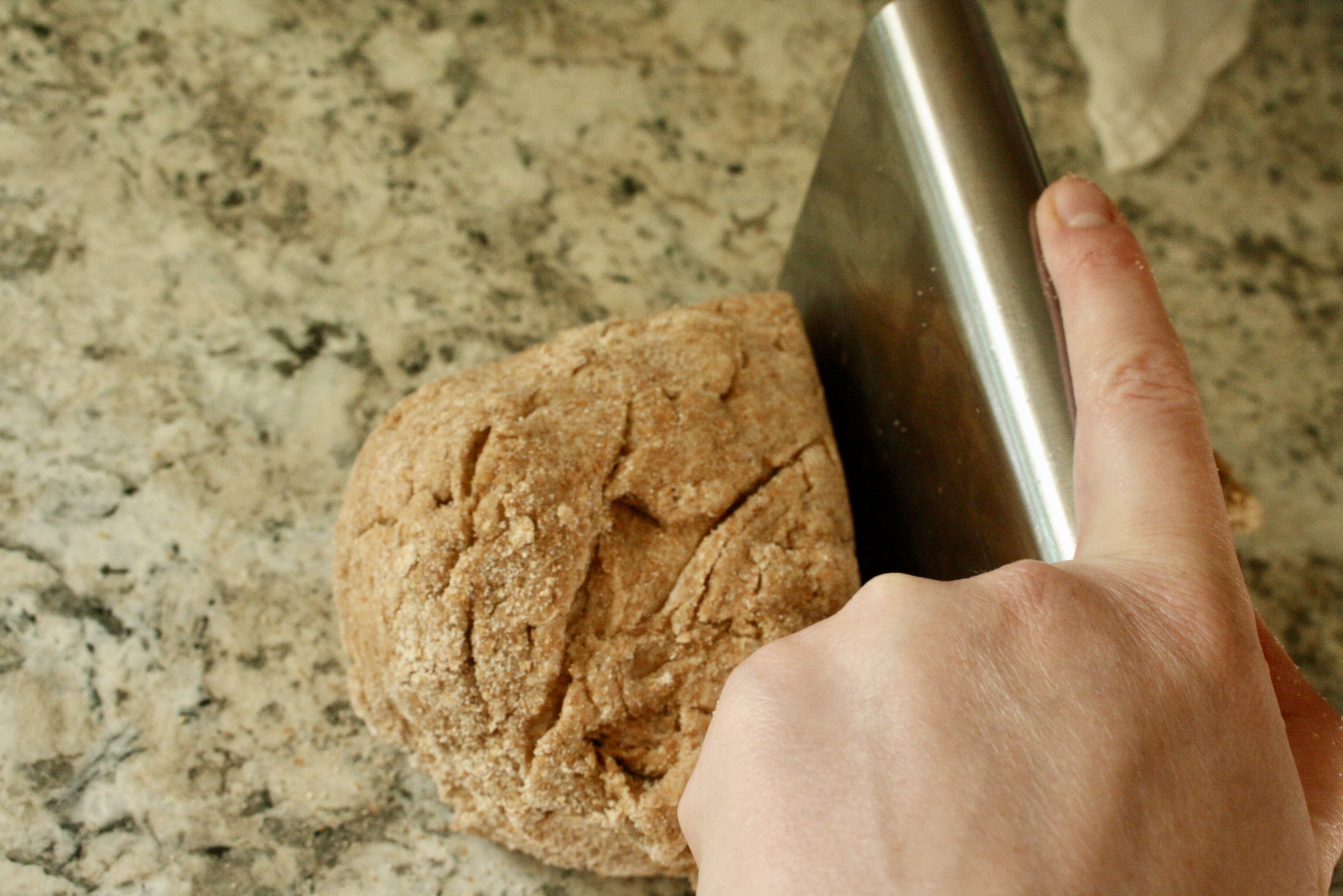 hand slicing dough in half