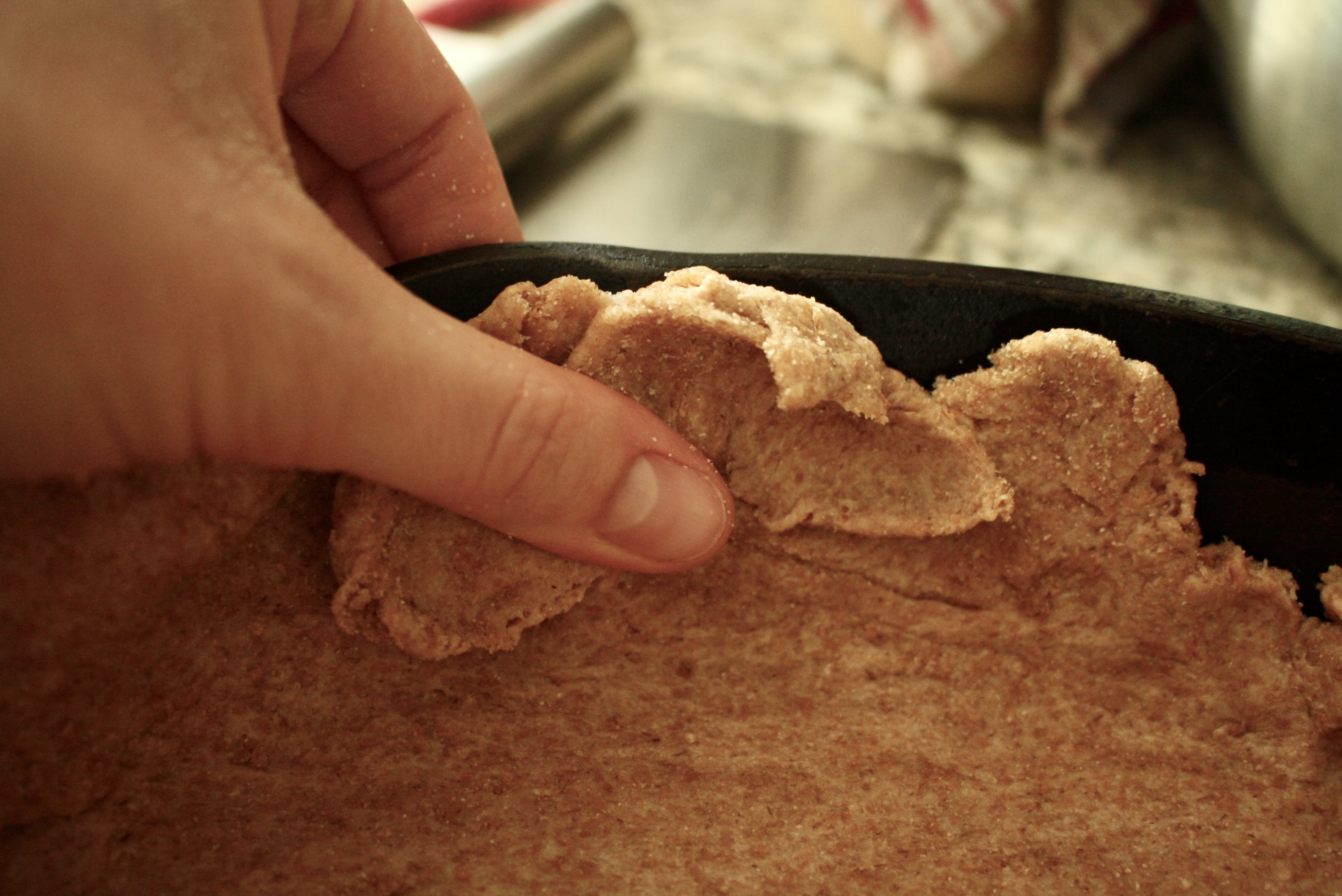 hand putting dough on skillet