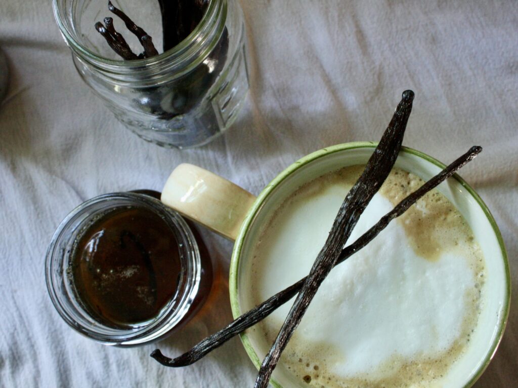 cup of coffee next to a jar of vanilla simple syrup