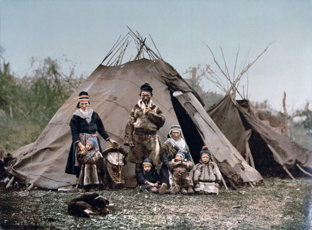 old photograph of a Sami family standing in front of their tent