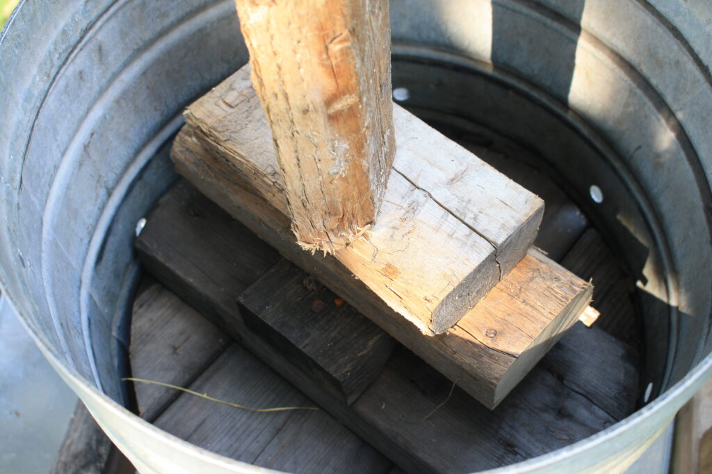 photo of the round wooden cover of the apple cider press with wooden blocks on top of it.