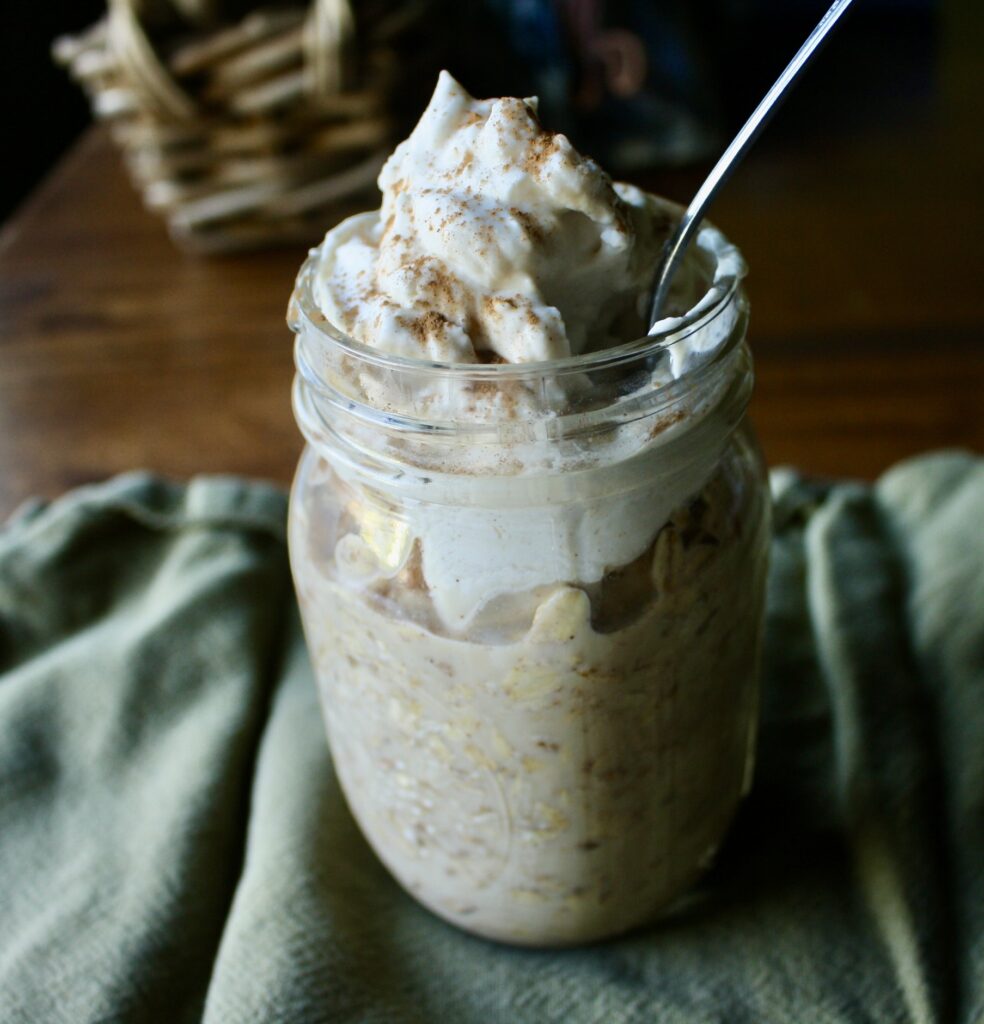 jar of overnight oats sitting on a table with a spoon in it