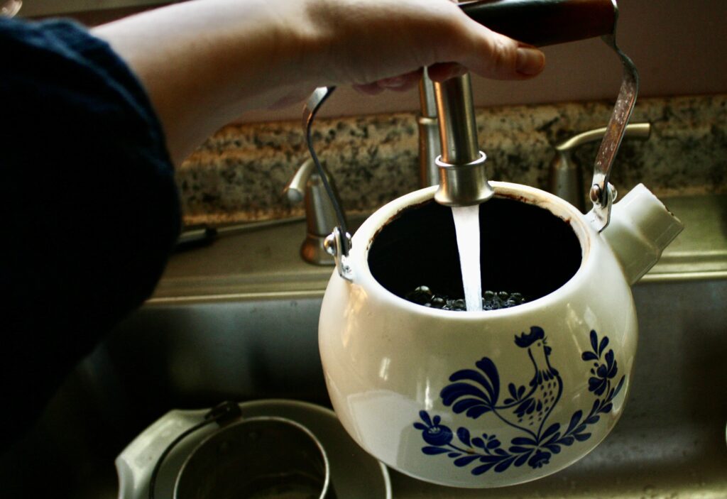 hand filling up kettle with water