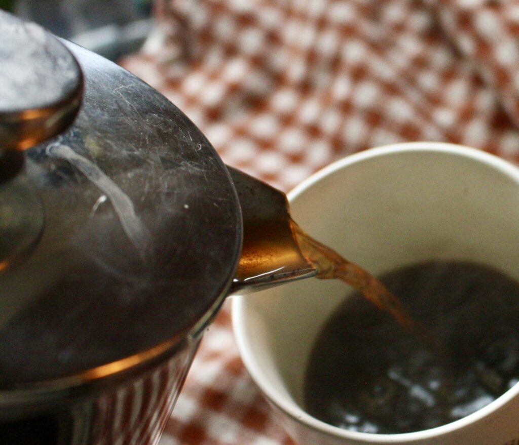 hot ginger coffee being poured into a mug from a French press