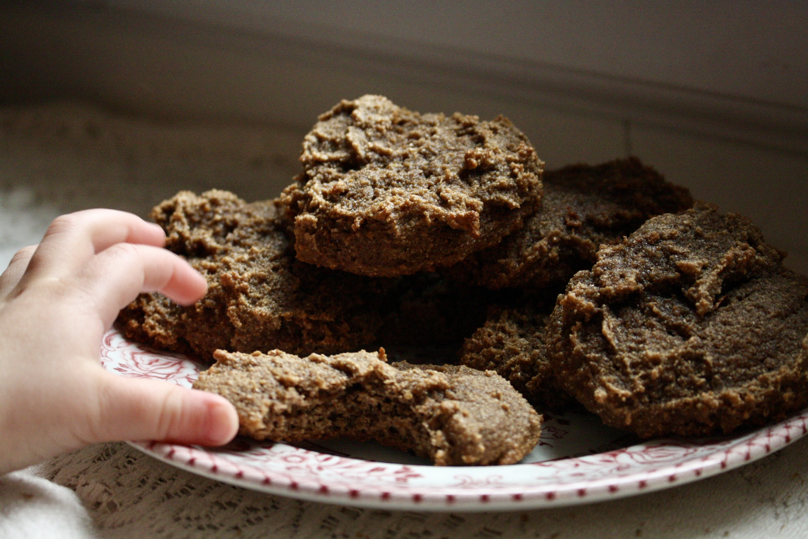 baby hand reaching for gingerbread cookie on a plate