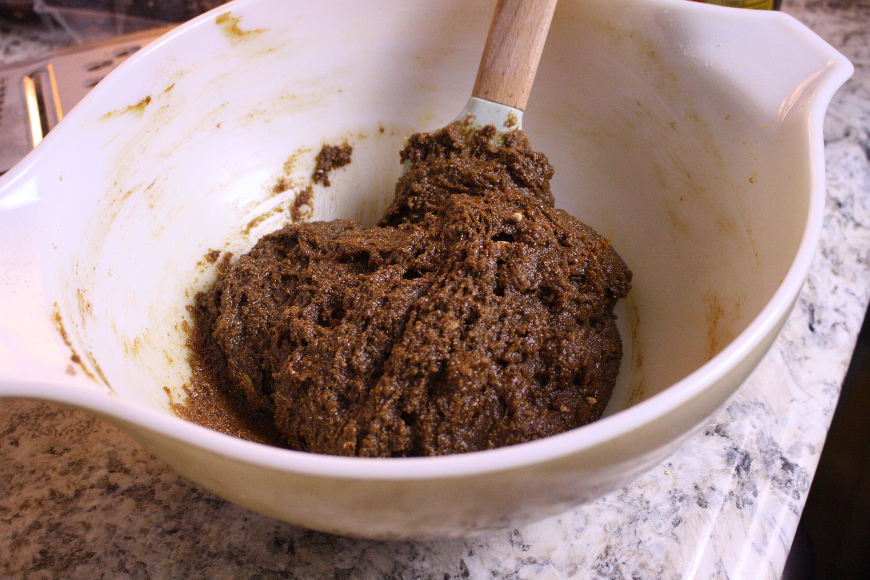 bowl of gingerbread dough being stirred with a spatula