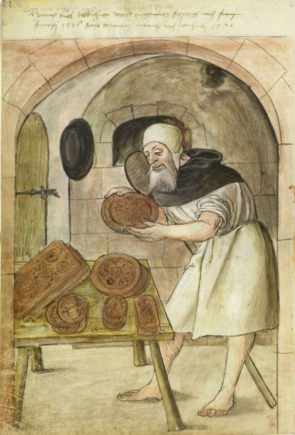 medieval color picture of a bearded gingerbread baker with a white smock and bare feet holding a gingerbread mould next to a table of moulds.  An oven and paddle are in the background