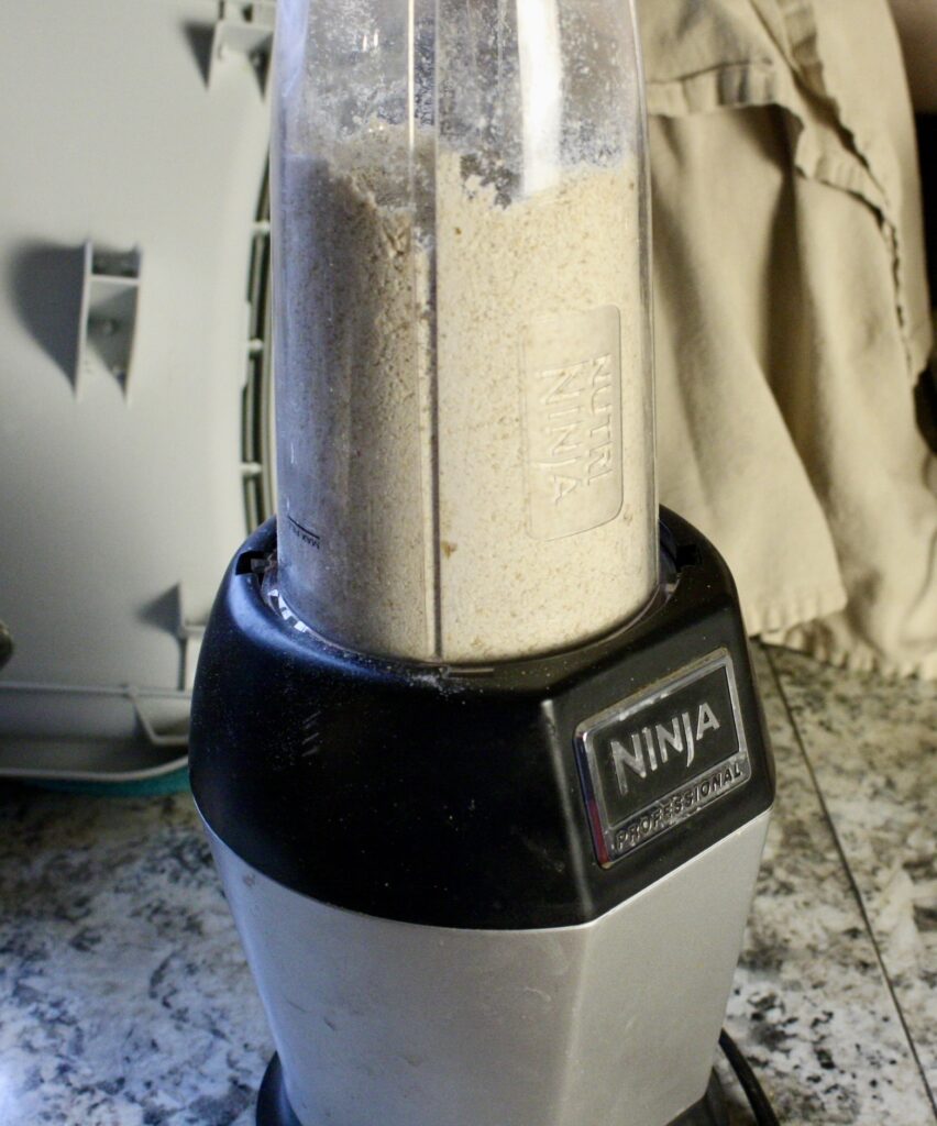 oat flour being blended in a ninja blender on a countertop.