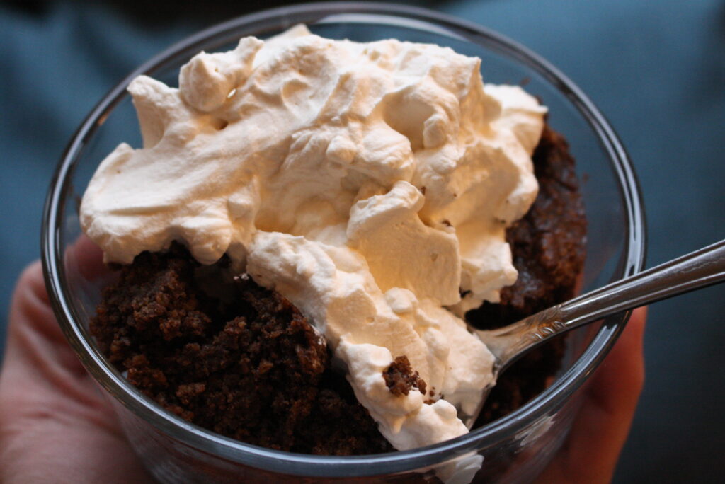 oat flour brownie with whipped cream on top in a glass bowl