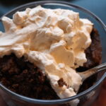 oat flour brownie with whipped cream on top in a glass bowl