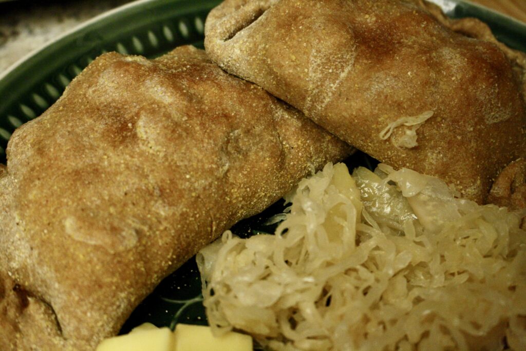 two pasties on a plate with sauerkraut