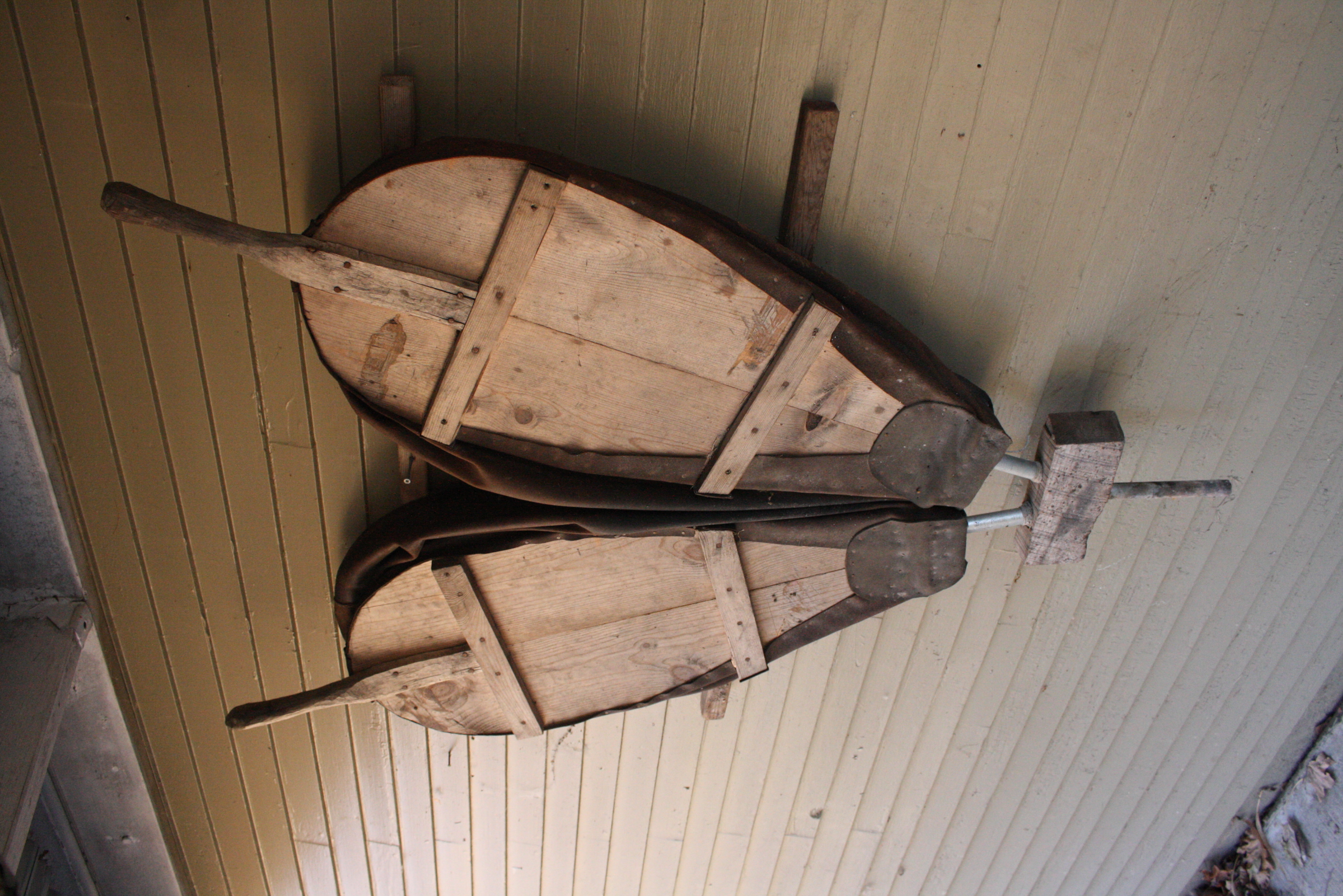 two forge bellows hanging on a wall.