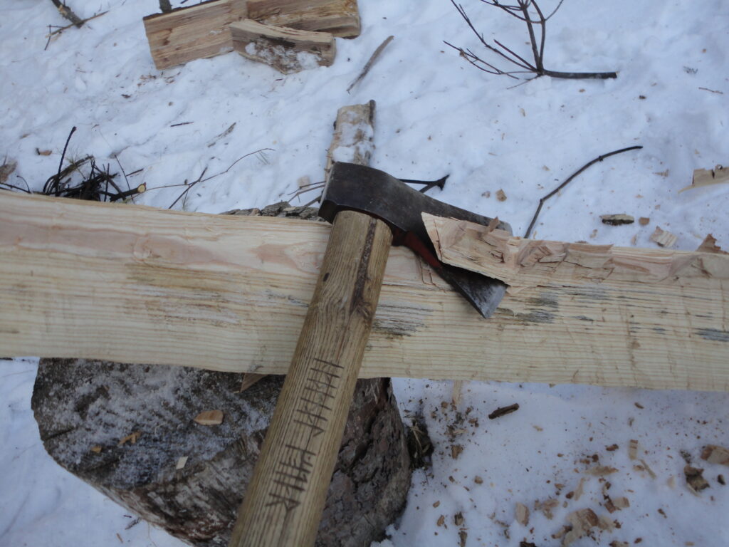 an axe carving a log down to make a medieval-style ski