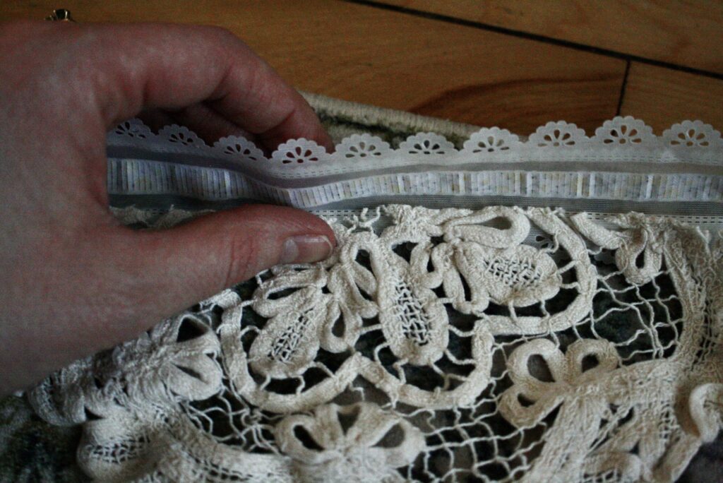 hand folding lace ribbon over the raw edge of a doily