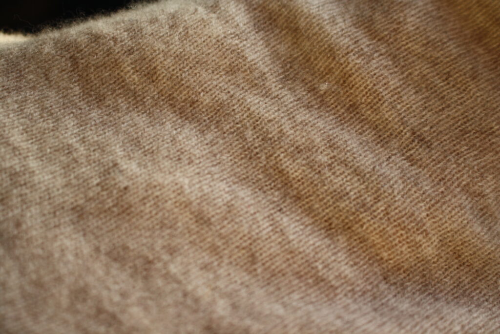 a close up photo of a tan cashmere sweater