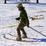 a man skiing down a hill with a single pole