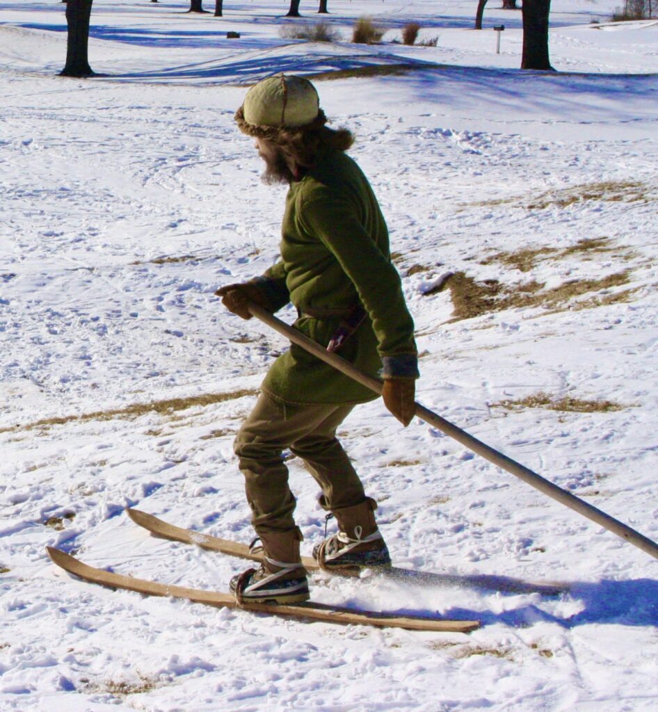 a man skiing down a hill with a single pole